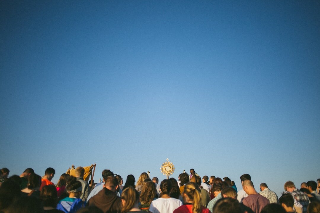 Diverse crowd watching a stage performance from behind at dusk